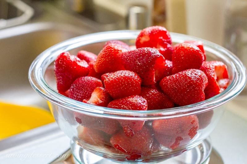 A bowl of red ripe strawberries with hulls removed.