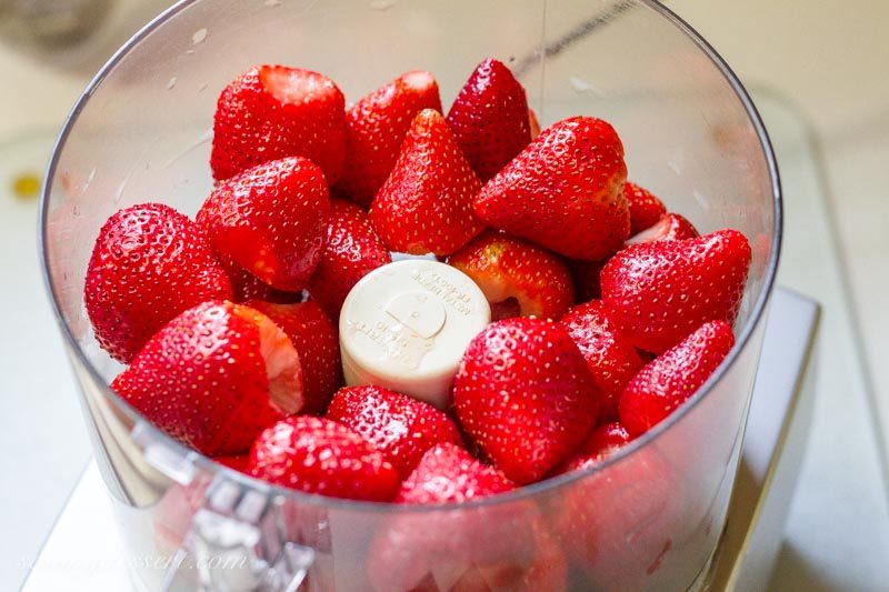fresh ripe strawberries in the bowl of a food processor
