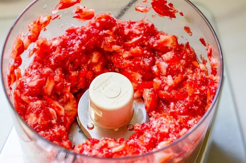 Chopped red ripe strawberries in the bowl of a food processor