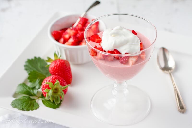 strawberry mousse with lemon whipped cream served in a clear glass dessert dish