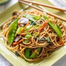 Close up of a plate of vegetable lo mein with chop sticks