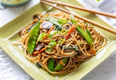 Close up of a plate of vegetable lo mein with chop sticks