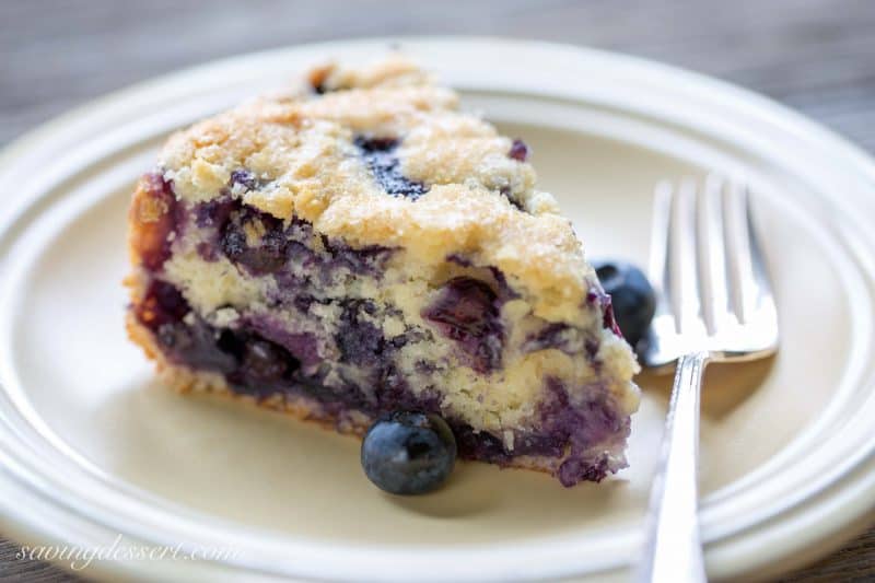 A slice of moist blueberry breakfast cake with a sugary crust on top