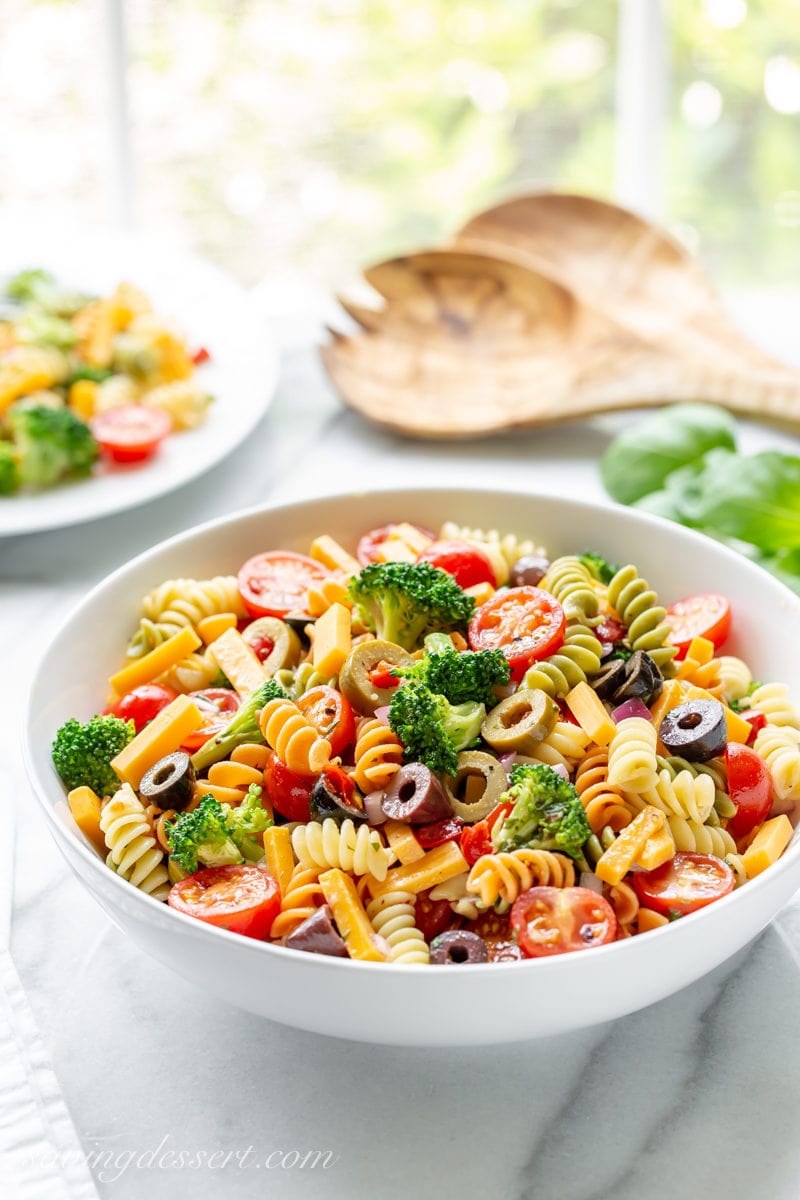 A bowl of summer pasta salad with Rotini spiral noodles, broccoli, cheese, olives and tomatoes