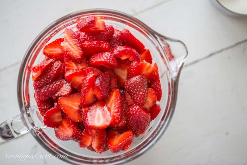 A mixing bowl filled with fresh sliced strawberries