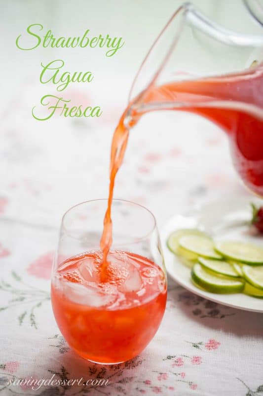 A glass of strawberry agua fresca with ice and ice