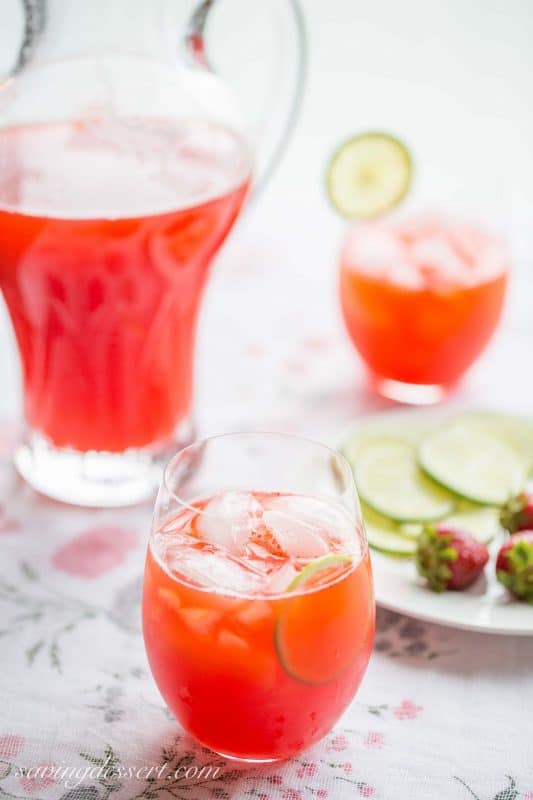 A pitcher and glasses of strawberry water with lime