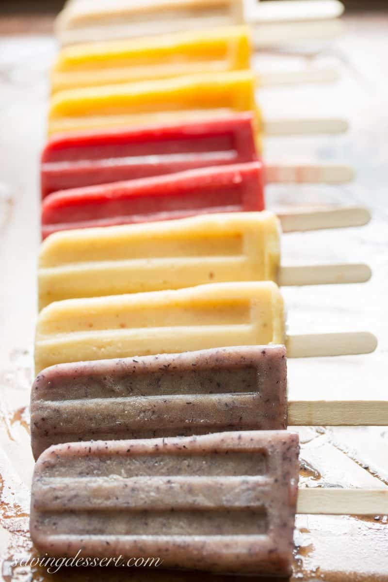 assorted fresh fruit popsicles lined up on a tray