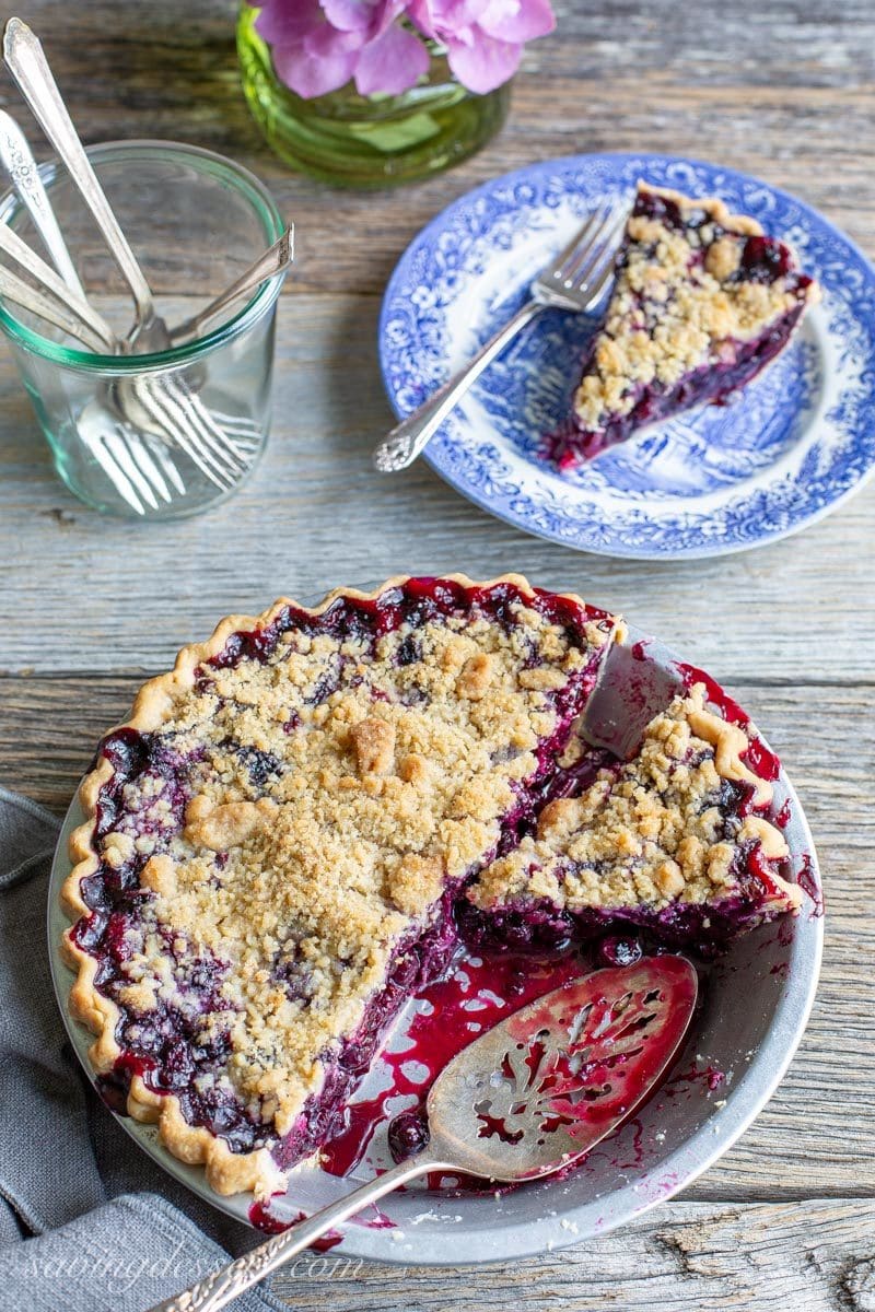 A sliced blueberry pie with blueberry juices all over the pan