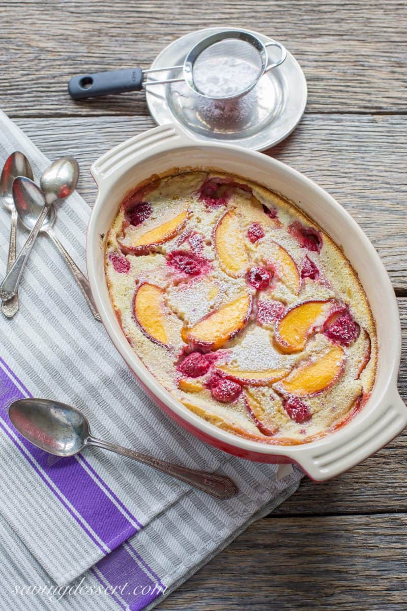 A casserole dish filled with a peach raspberry clafoutis.