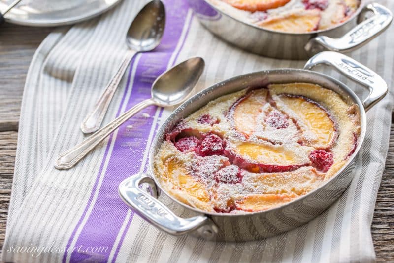 Raspberry Peach Clafoutis (pronounced klafuti) is a traditional French dessert made with seasonal fresh fruit, covered in a thick custard-like batter, then baked. It is often served warm with a dusting of confectioners' sugar. 