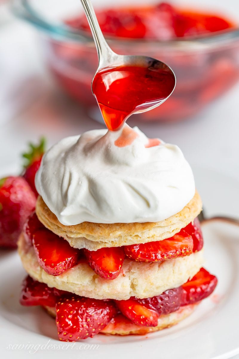 Strawberry Shortcake Scones stacked with fresh strawberries, whipped cream and strawberry syrup