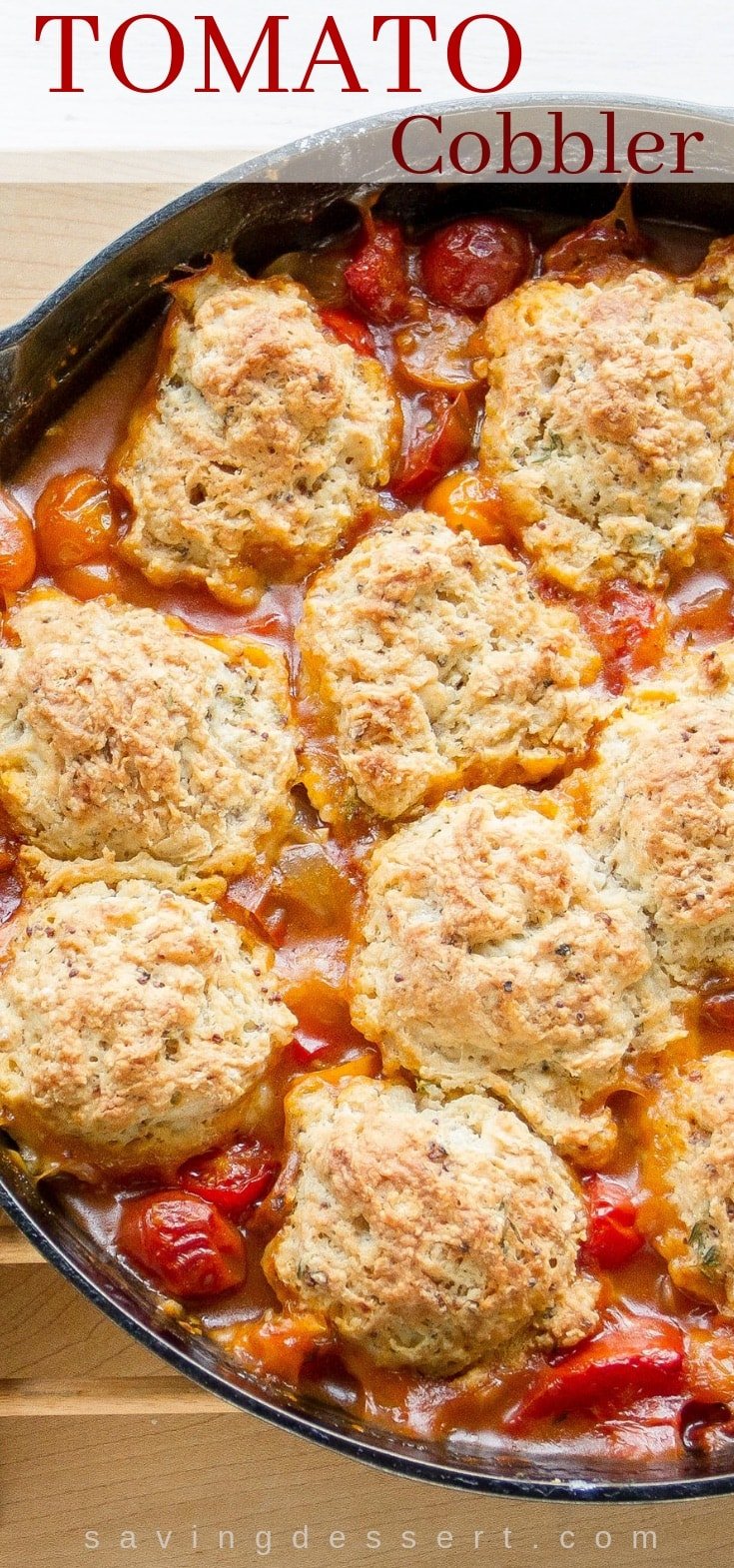 A skillet with savory tomato cobbler topped with herbed biscuits