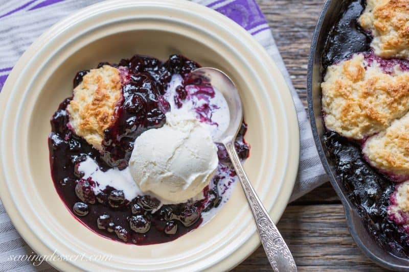 Black Raspberry Cobbler in a bowl topped with a scoop of ice cream