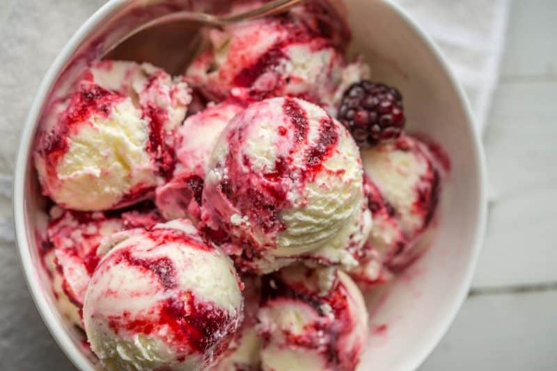 Scoops of Lemon Ice Cream in a bowl with a Blackberry Swirl