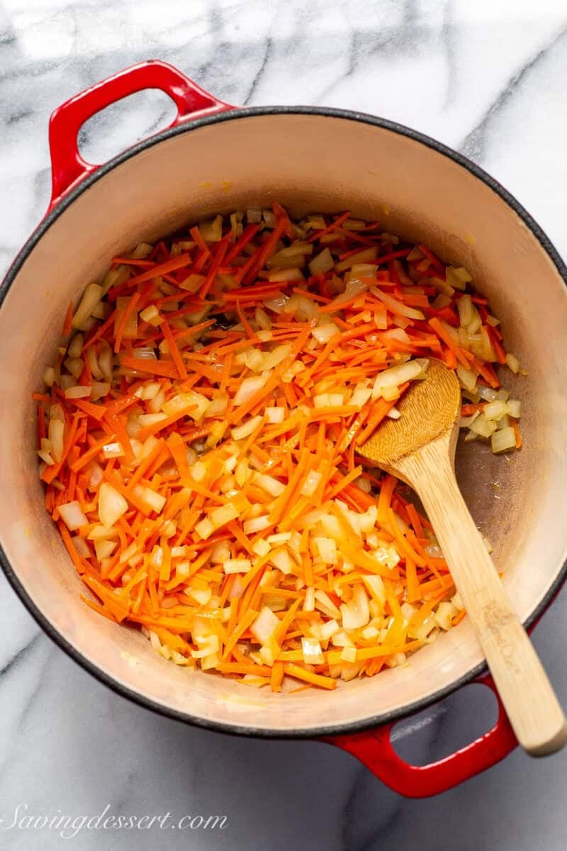 Match stick carrots and chopped onions in a Dutch oven.