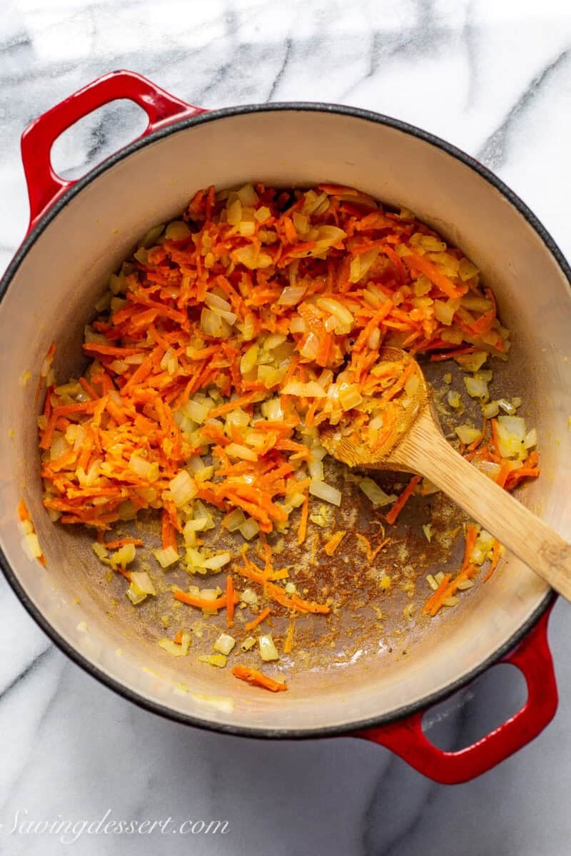 Carrots and onions sautéed in a Dutch oven pot.