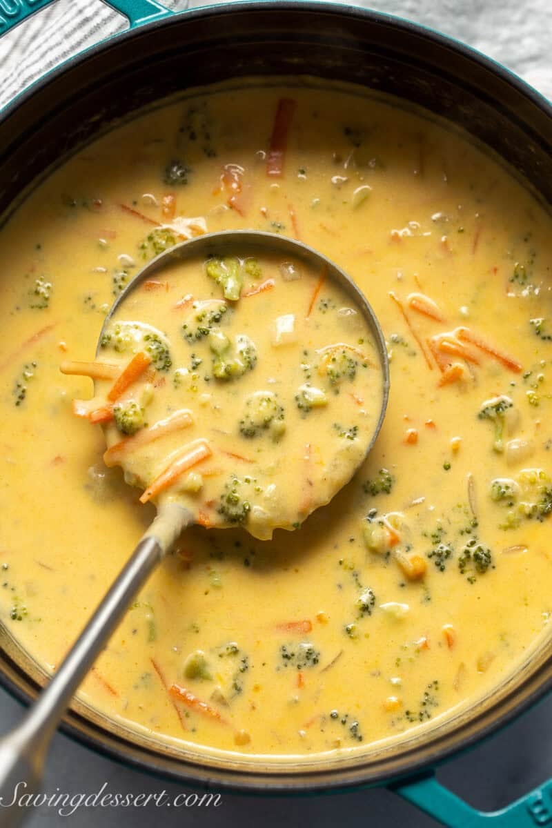 An overhead shot of a pot of broccoli soup with a ladle scooping some out.