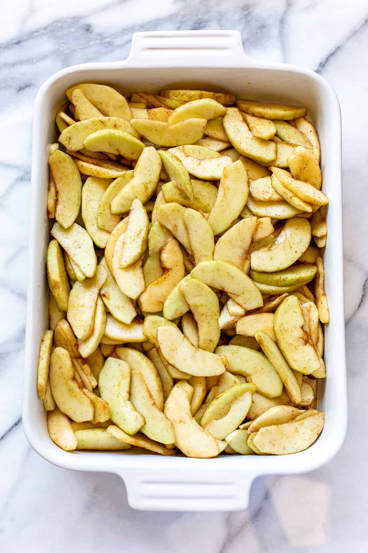Sliced apples and sugar in a casserole dish