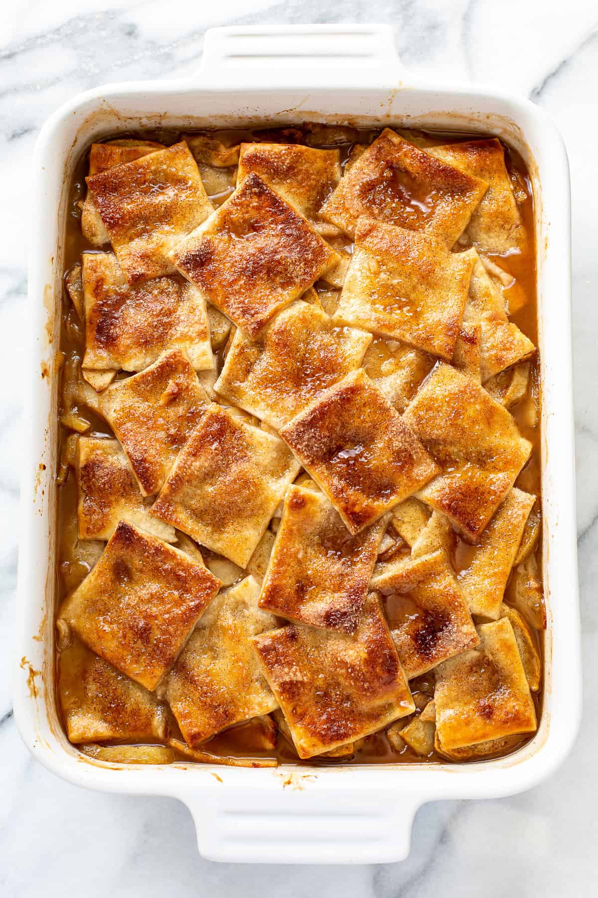 A pan of apple pandowdy with a golden brown top with a cinnamon sugar crust