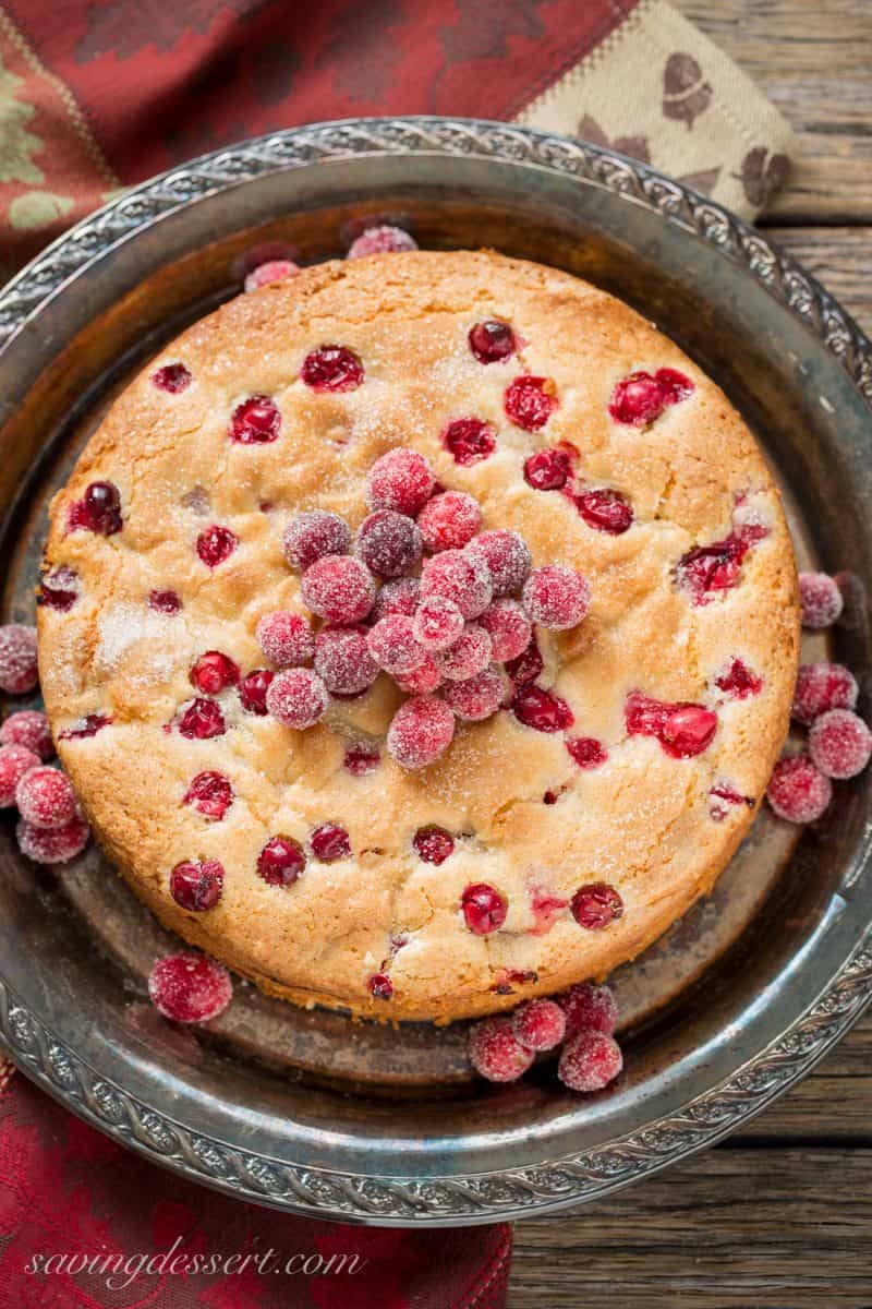 An overhead view of a cranberry almond breakfast cake topped with sugared cranberries