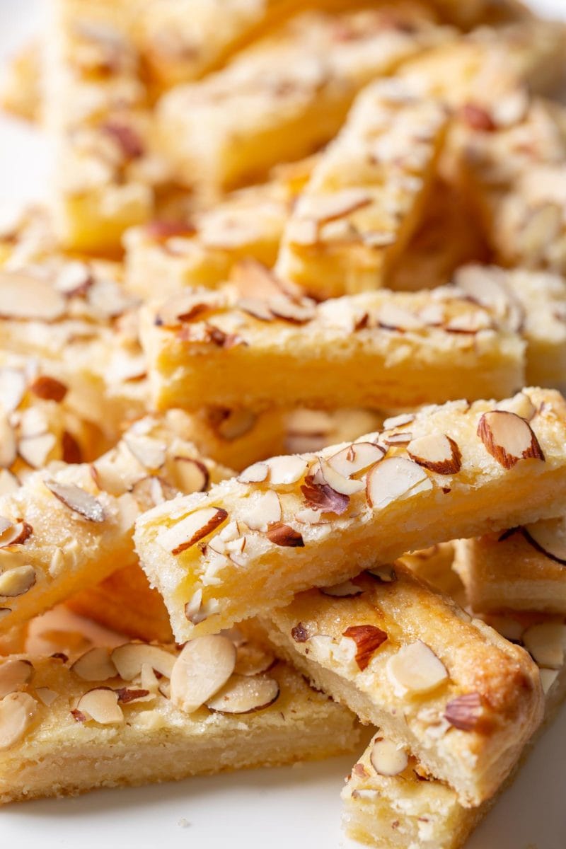 Almond cookies sliced into bars on a platter. Topped with sliced almonds