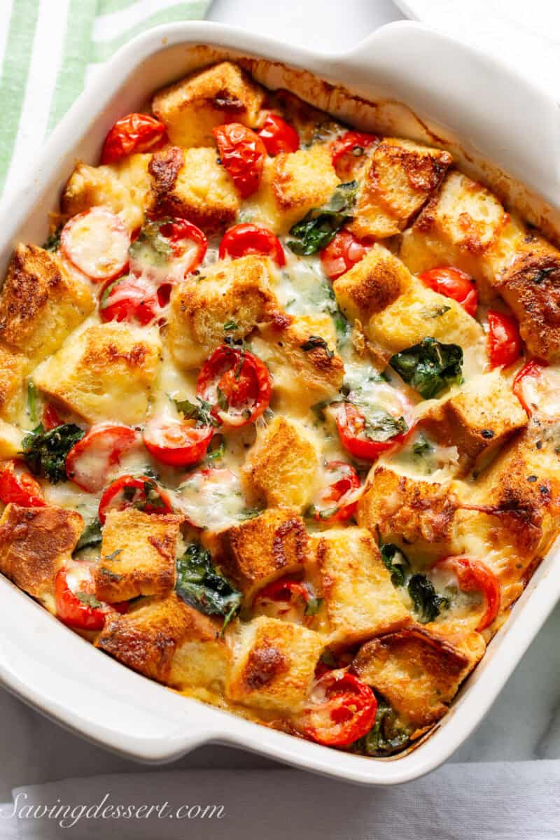 A baked vegetable breakfast strata in a square casserole dish.