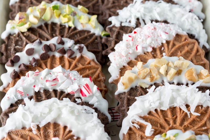 Chocolate Pizzelles dipped in white chocolate with peppermint, walnuts, chocolate chips, coconut and pistachios