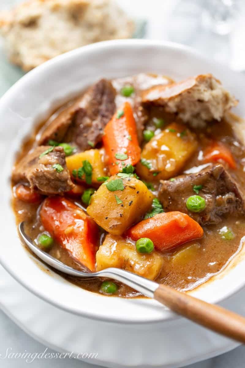 A bowl of beef stew with a spoon.