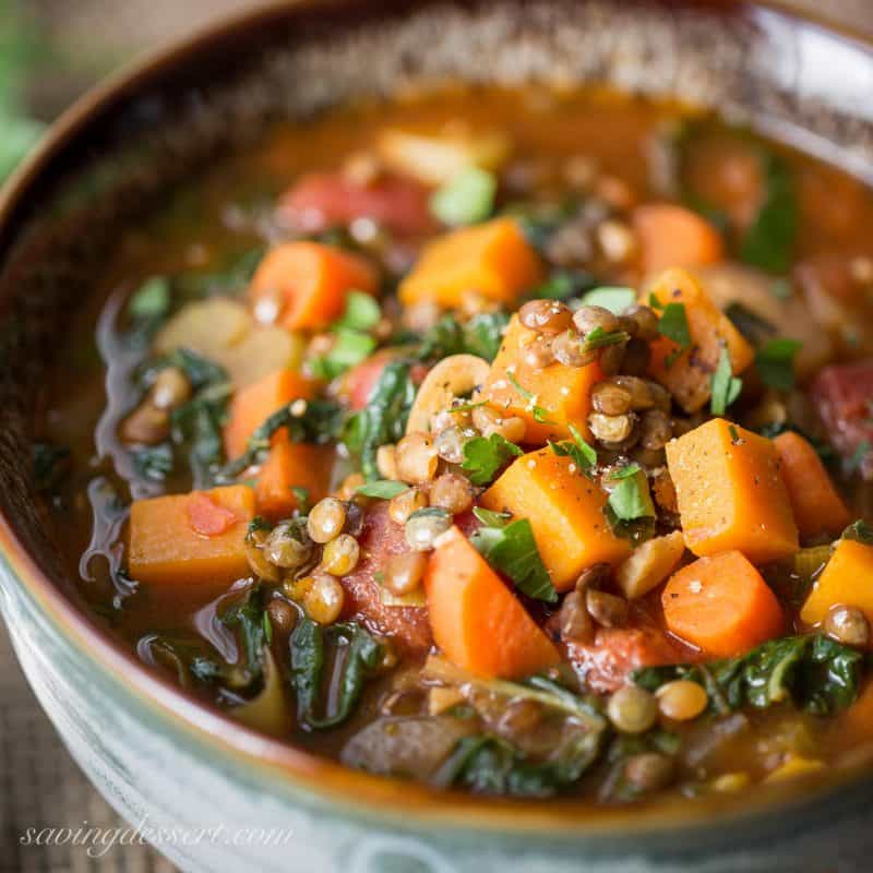 A bowl of vegetable soup with lentils and seasonal greens