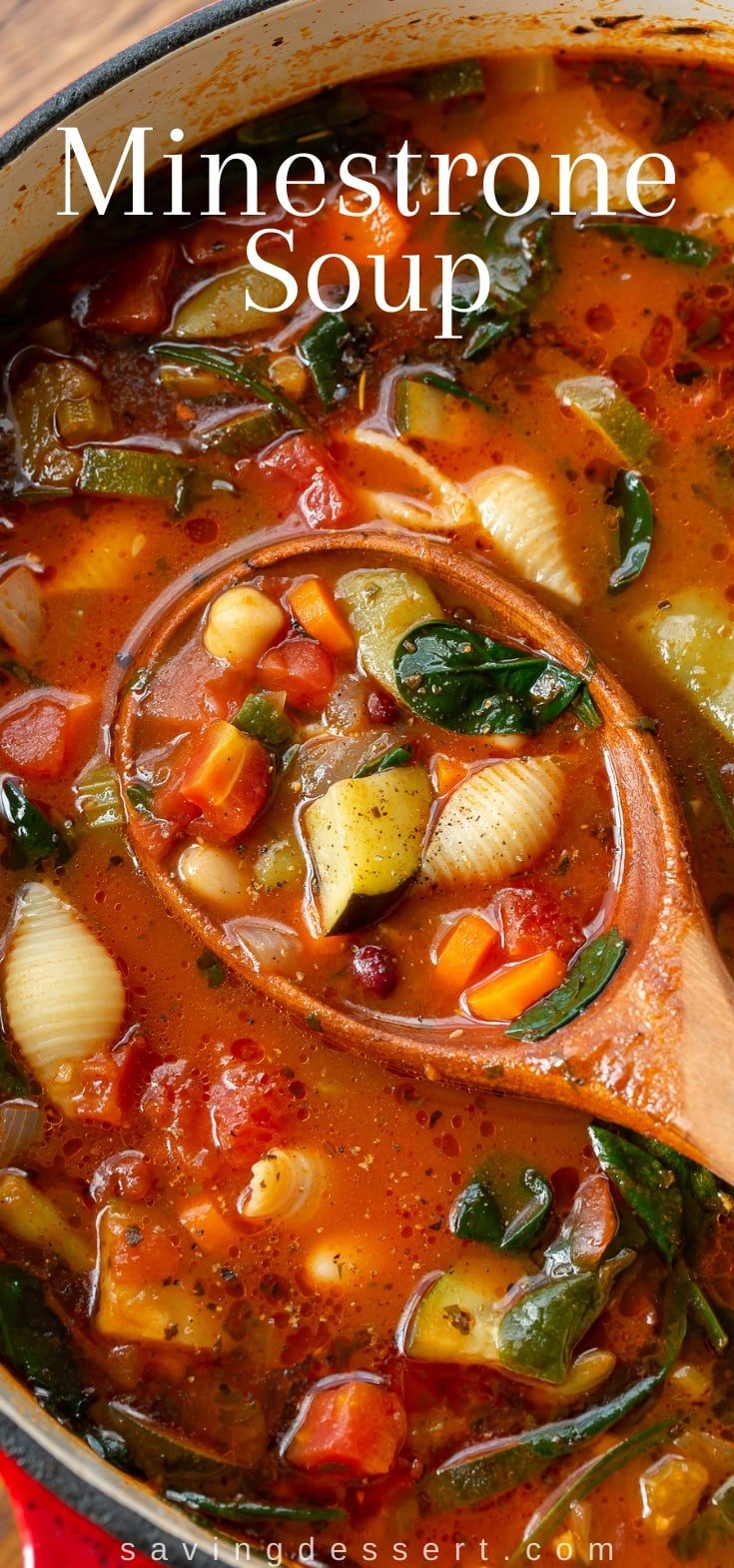 A ladle filled with Minestrone Soup with spinach and shell shaped pasta