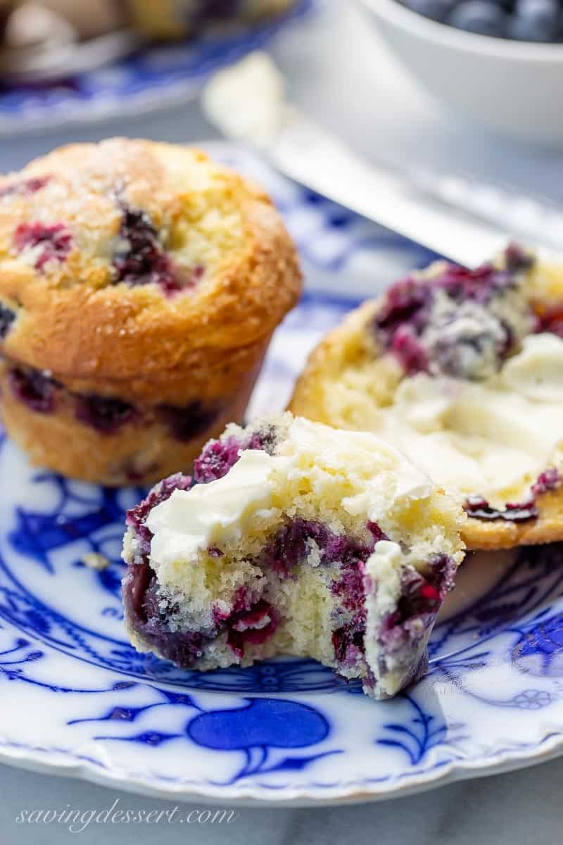 A blueberry muffin broken open with a bite take out