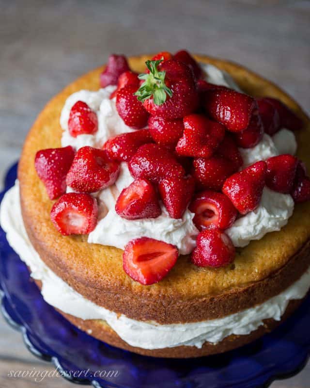 An overhead view of a fresh Strawberry Mascarpone Cake topped with whole strawberries