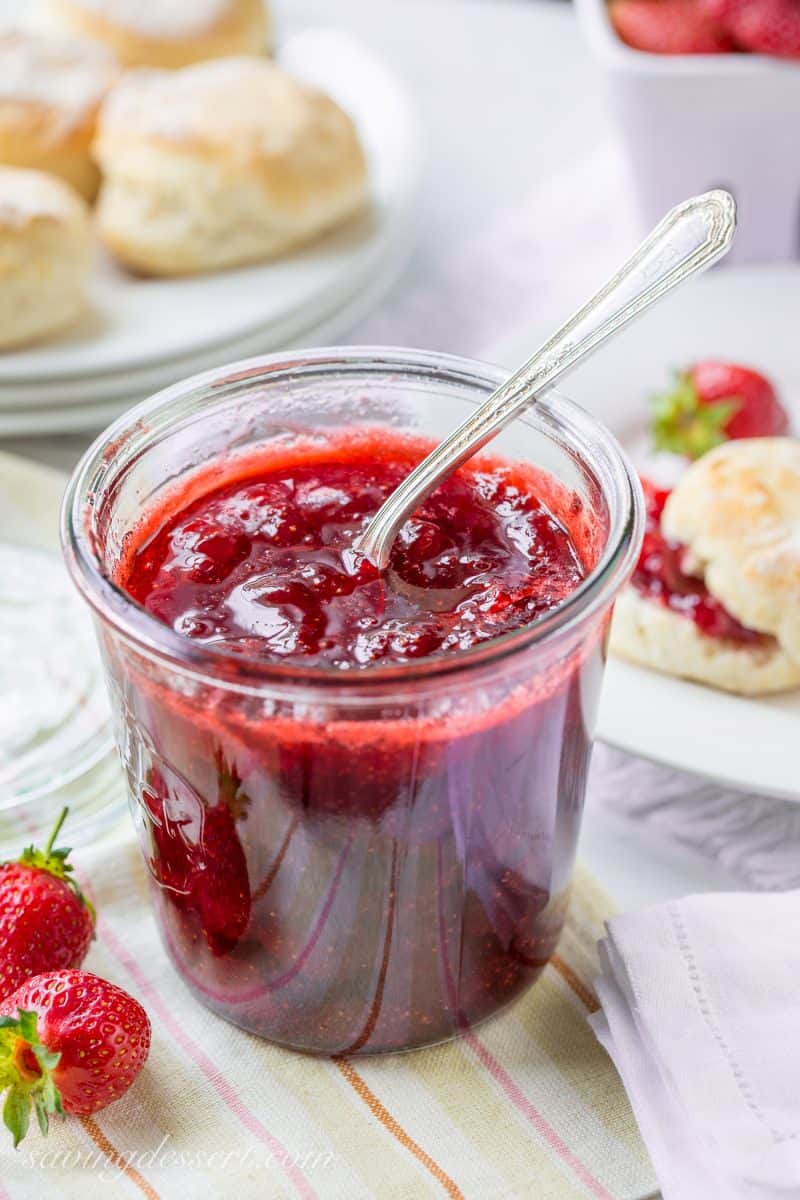 A jar of homemade strawberry jam with a spoon