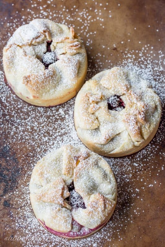 Mini deep dish berry pies on a baking pan