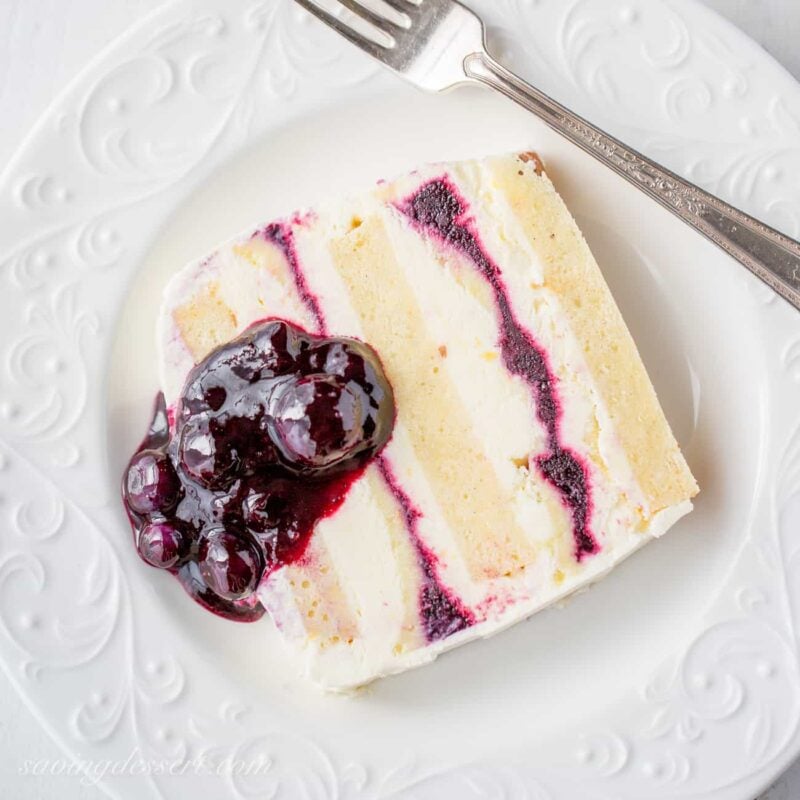 A slice of blueberry lemon icebox cake with blueberry sauce on top