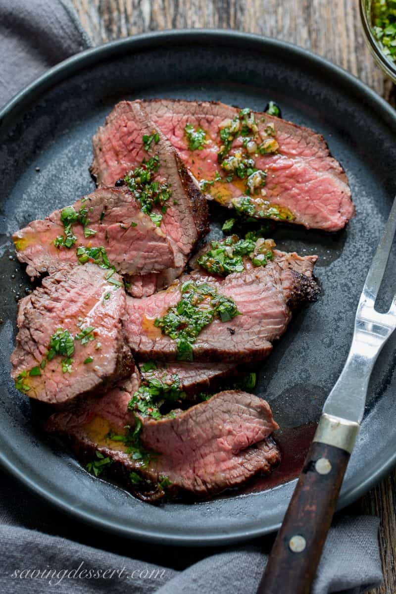 Grilled Tri-Tip Roast with Chimichurri on a black plate