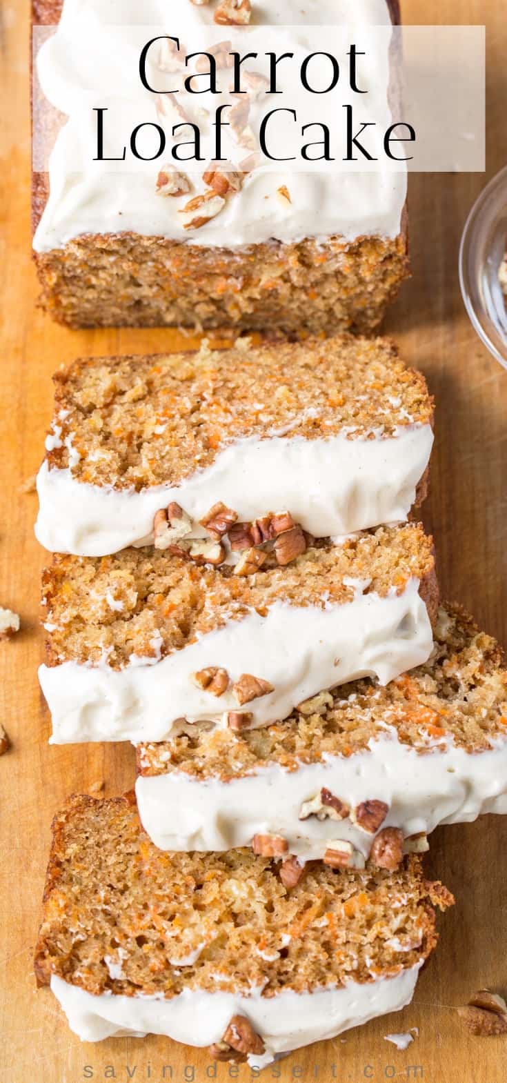 Sliced Carrot Loaf Cake topped with cream cheese icing on a cutting board