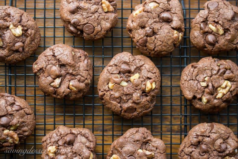 Thick and chewy Chocolate Chocolate-Chip Walnut Cookies have crispy edges, a soft almost brownie-like middle, and are loaded with big chunks of walnuts. www.savingdessert.com