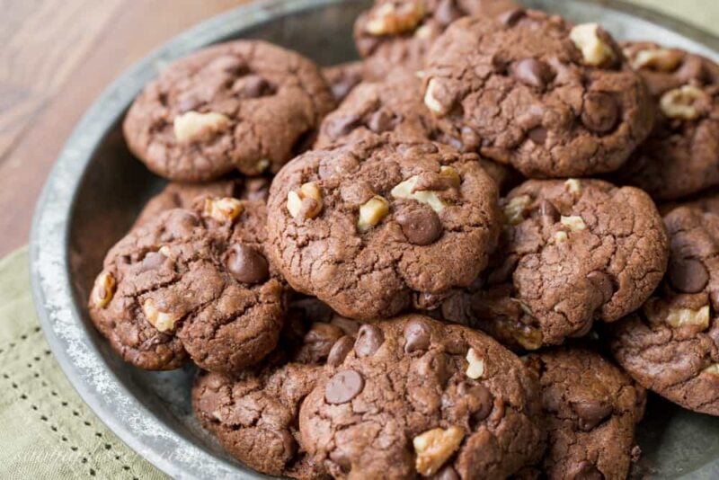 Thick and chewy Chocolate Chocolate-Chip Walnut Cookies have crispy edges, a soft almost brownie-like middle, and are loaded with big chunks of walnuts. www.savingdessert.com