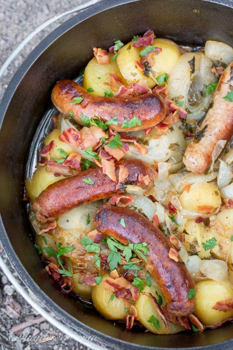 A cast iron Dutch oven with potatoes, onions, bangers and bacon - the Double Coddle