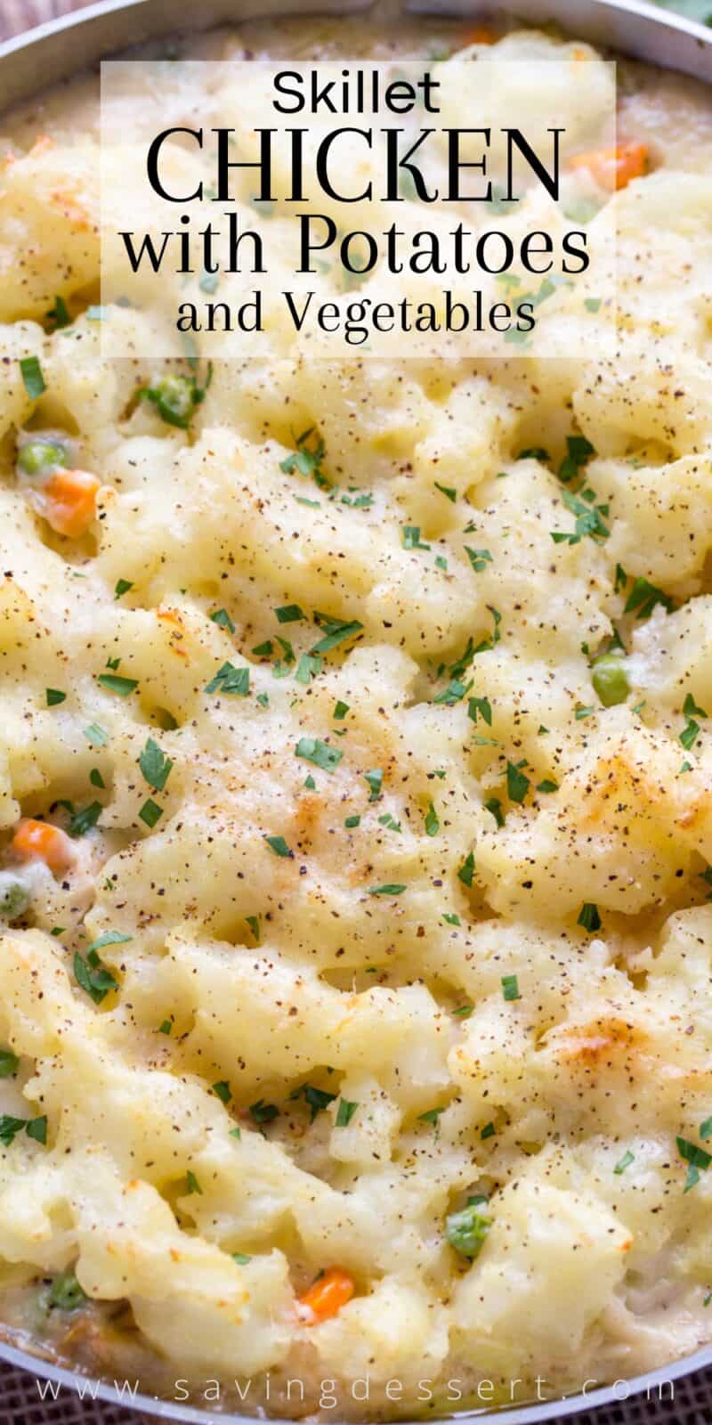 Overhead view of a skillet filled with creamy chicken and vegetables topped with potatoes