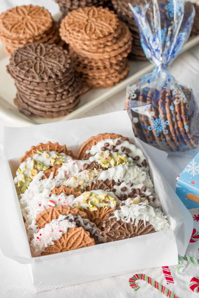 Chocolate Pizzelles dipped in white chocolate and decorated with coconut, crushed peppermint, nuts and mini chocolate chips