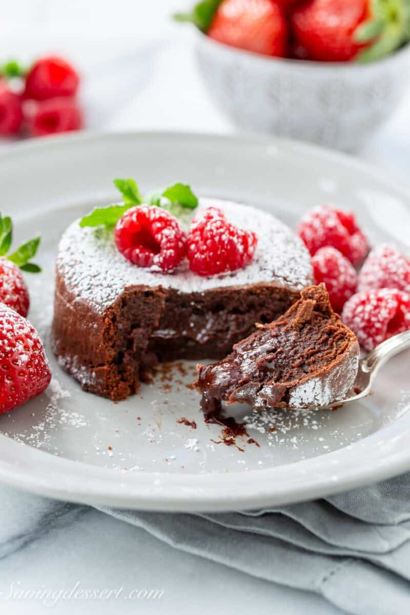 A spoonful of molten lava cake served with strawberries and raspberries.