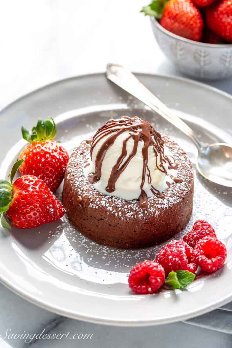 Chocolate Lava Cake topped with vanilla ice cream, a chocolate drizzle and fresh berries.