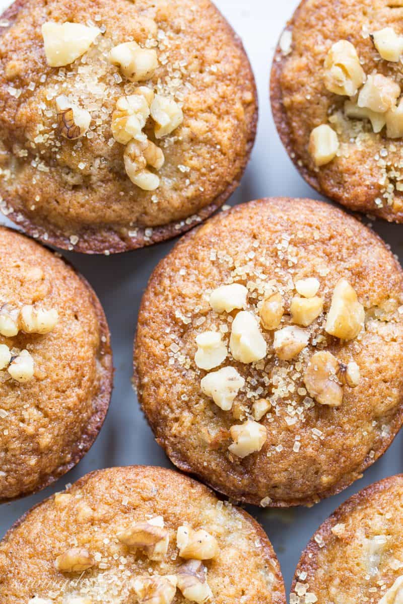 A closeup of walnut topped muffins sprinkled with coarse sugar