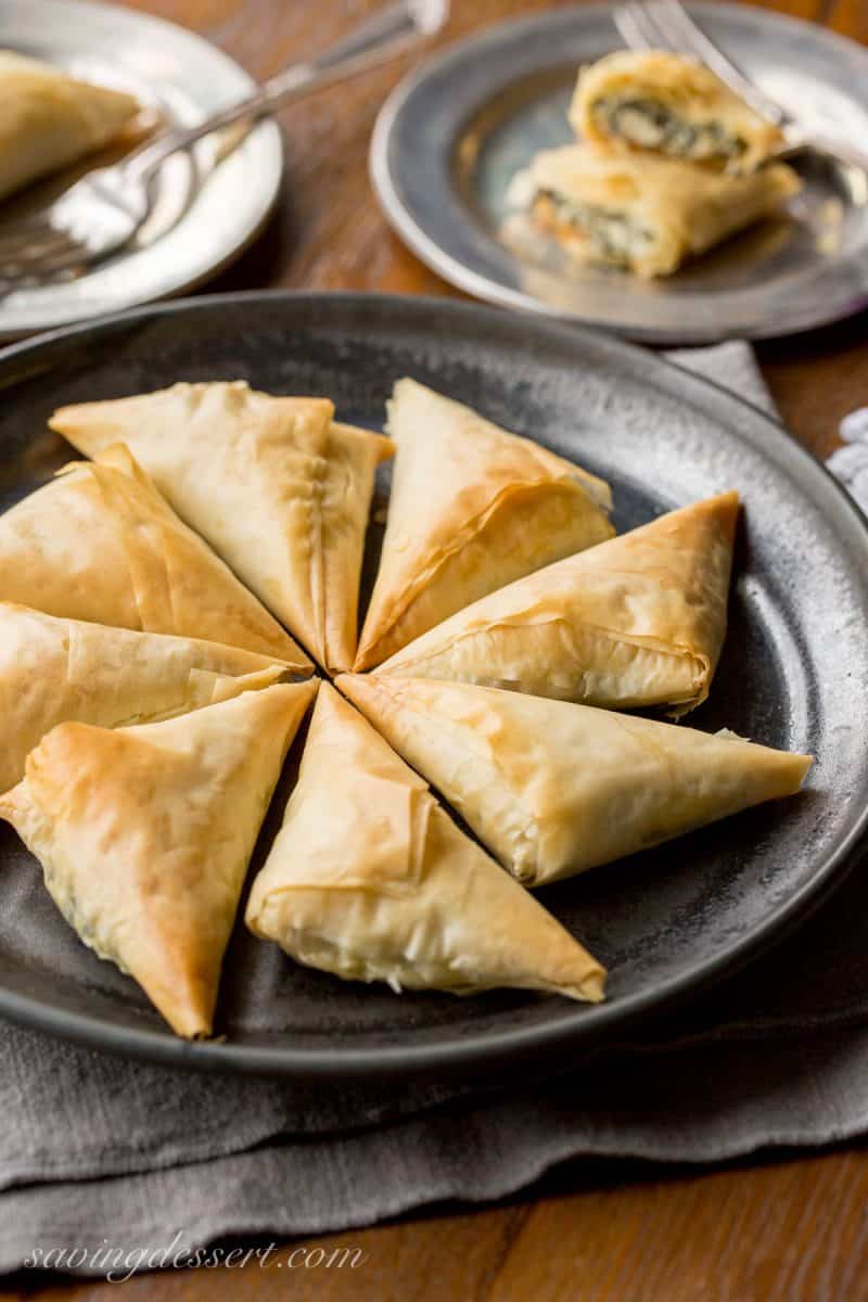 A plate of Greek Spanakopita (Greek spinach and feta pie) formed into wedges and baked until golden brown