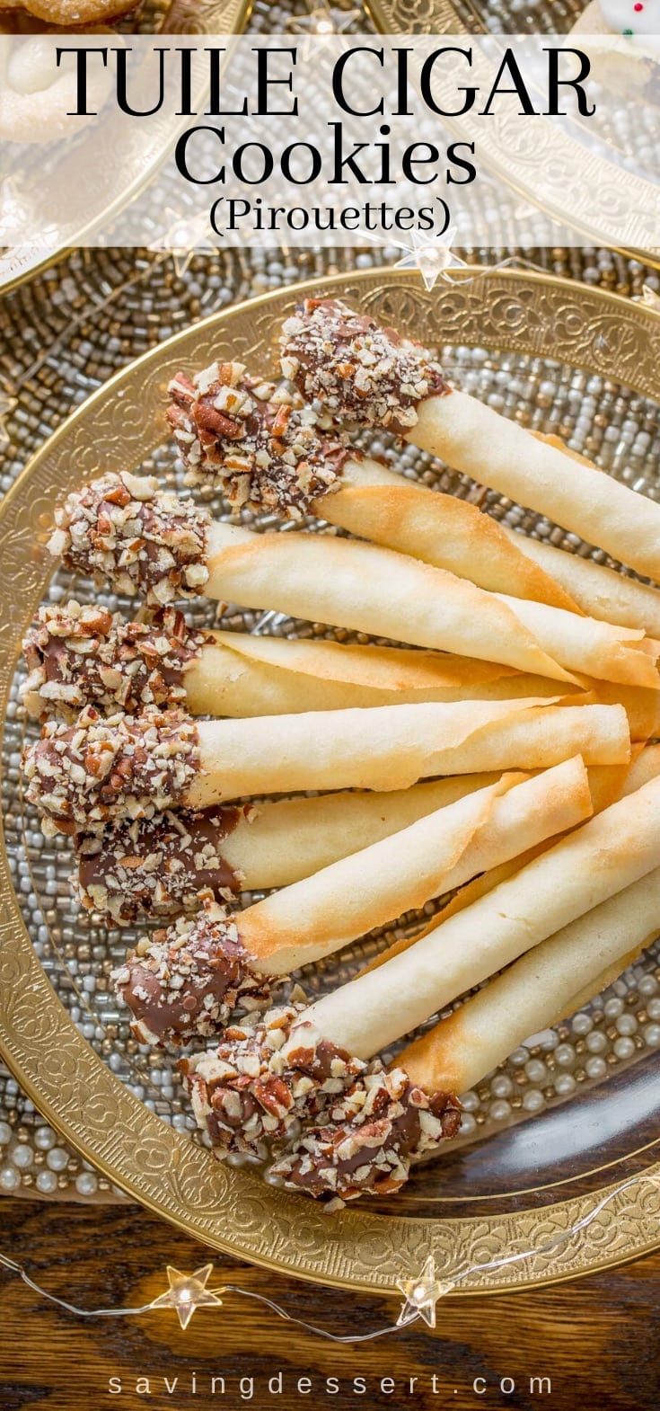 A plate of tuile cigar cookies dipped in chocolate and coated in chopped pecans.