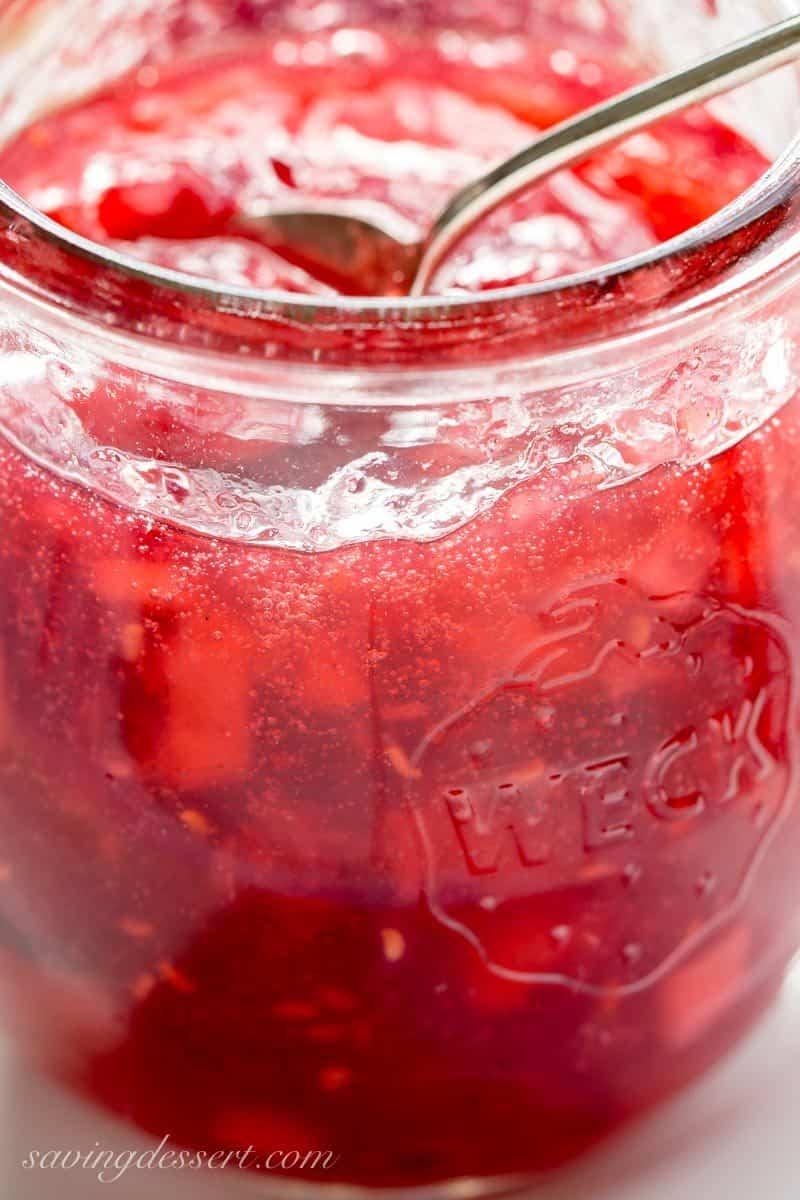 Holiday Jam ~ a wonderful combination of cranberries, raspberries, and pears with a touch of spice and a splash of Grand Marnier! This quick & easy freezer jam recipe will thrill you and your guests. Dressed up in a pretty jar, this makes a wonderful gift! www.savingdessert.com