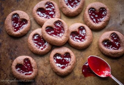 Chocolate Raspberry Thumbprint Cookies - who can resist the classic combination of raspberries and chocolate?! This little chocolate cookie boasts plenty of chocolate flavor and a fun little heart shaped thumbprint filled with seedless raspberry jam. An easy and delicious cookie with a Valentine's Day theme for your sweetie! www.savingdessert.com